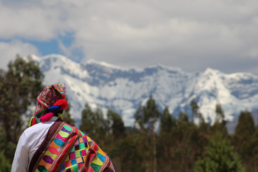 Mujer con vestimenta andina frente al nevado Ausangate